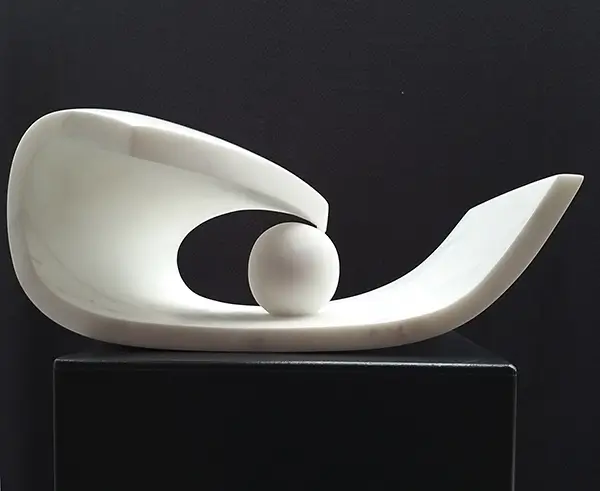 Seitenansicht der Marmorskulptur Die gefangene Kugel von Renate Jacobs